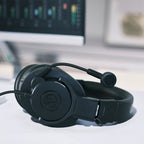 Audio-Technica ATH-M20xSTS resting on a desk beside a monitor