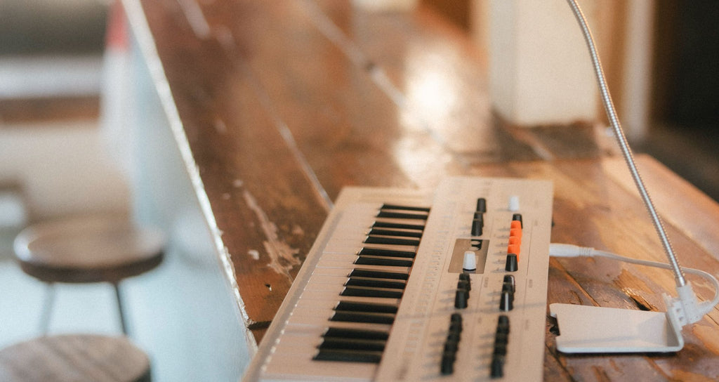 Arturia MiniFreak synthesizer with vocoder feature, showing control panel and keyboard in a studio setting.