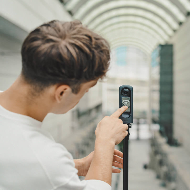 Ricoh Theta X 360-degree video camera with lens and controls, designed for high-quality immersive video recording.