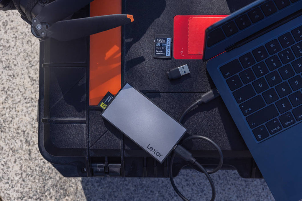 Lexar Workflow SD and microSD UHS-II card reader connected to a computer with multiple memory cards inserted for data transfer.