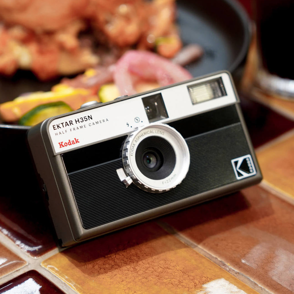 Kodak EKTAR H35N compact instant camera with vintage design, featuring a sleek black body and manual controls.