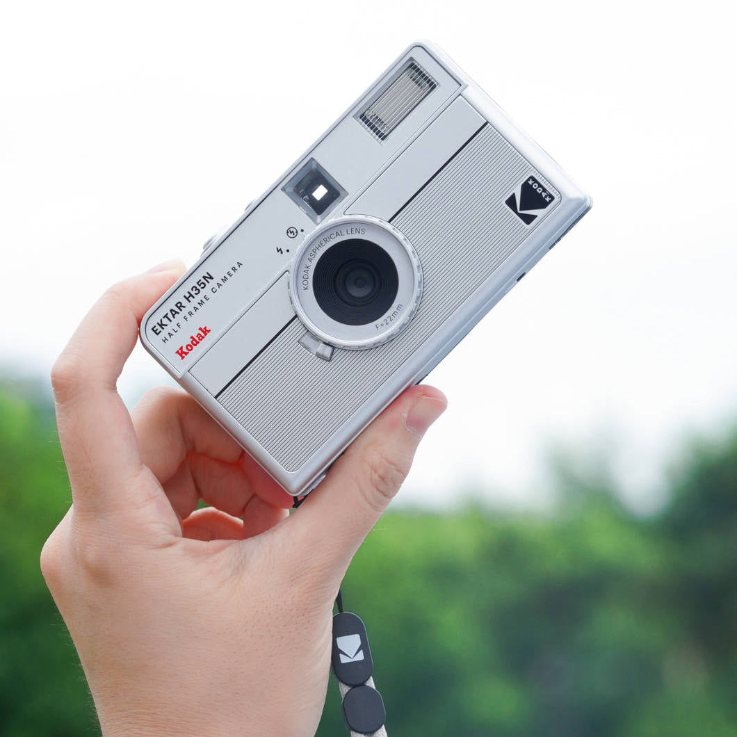 Kodak EKTAR H35N compact instant camera with vintage design and lens, white body, and manual controls for instant photography.