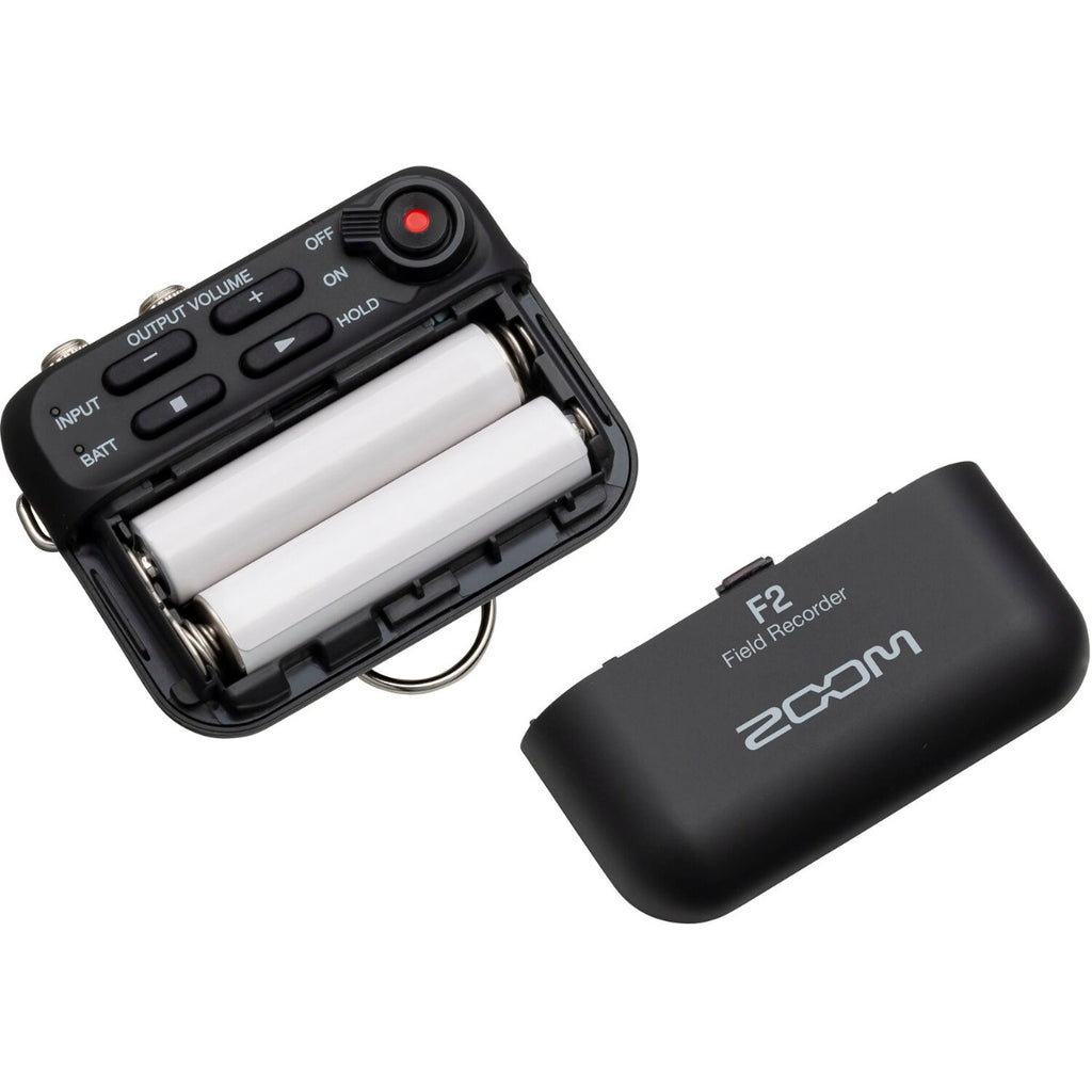 Zoom F2 digital recorder with compact design and multiple input options, shown with attached microphone and controls.