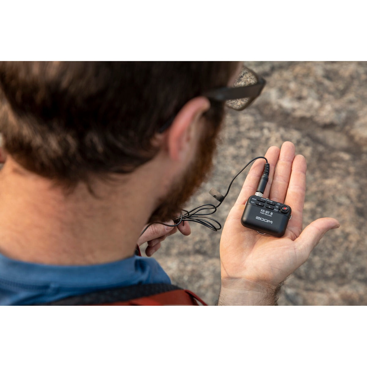 Zoom F2 digital recorder with compact design, multiple input ports, and a black body, ideal for high-quality audio recording.