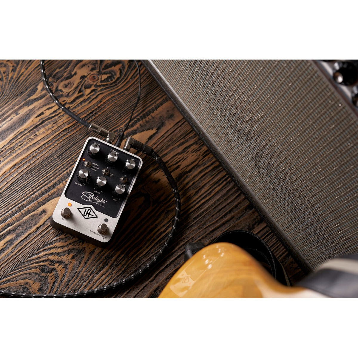 Universal Audio UAFX Starlight Echo Station effects pedal with knobs and switches on a wooden surface.