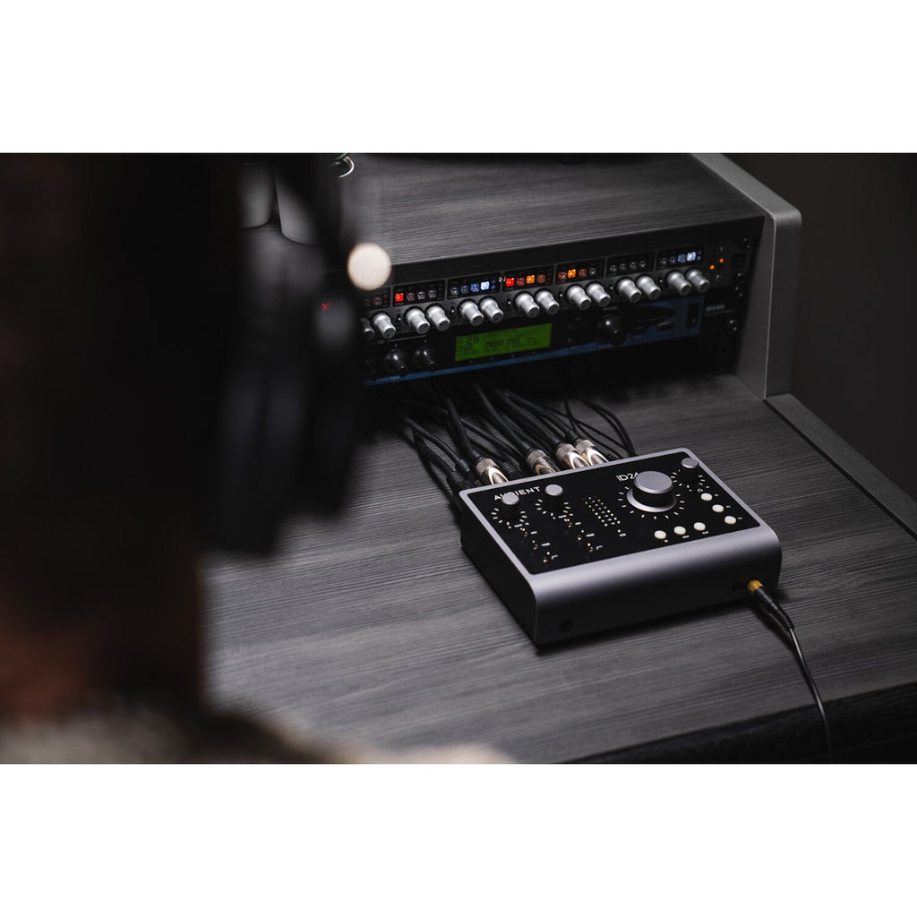 Audient iD24 audio interface with multiple input and output ports, compact black design, and professional audio equipment setup