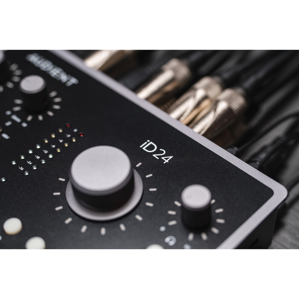 Audient iD24 audio interface with multiple input/output ports and control knobs, set on a desk with a computer and studio equipment