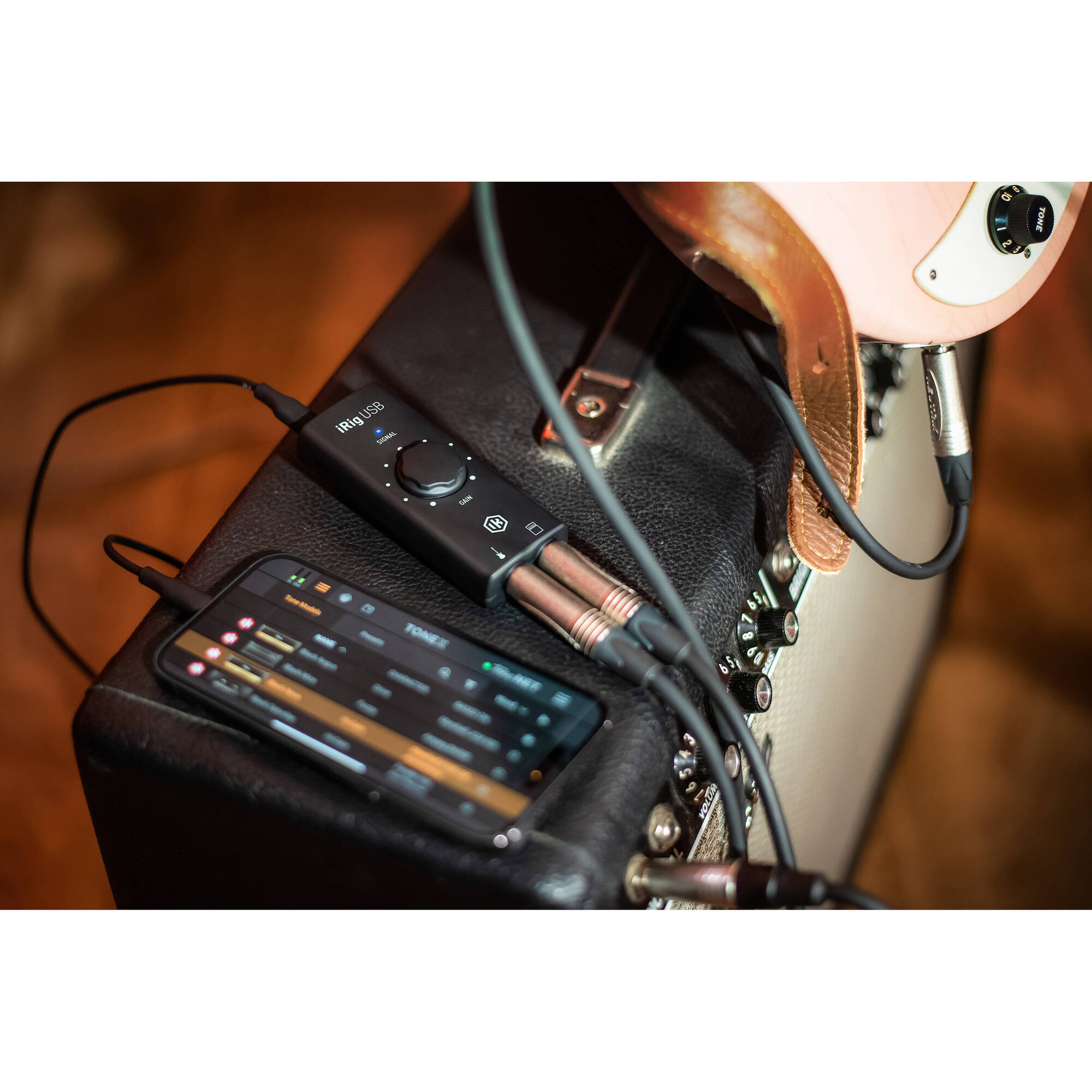 IK Multimedia iRig USB audio interface connected to a computer, showing input and output ports for music and recording purposes.