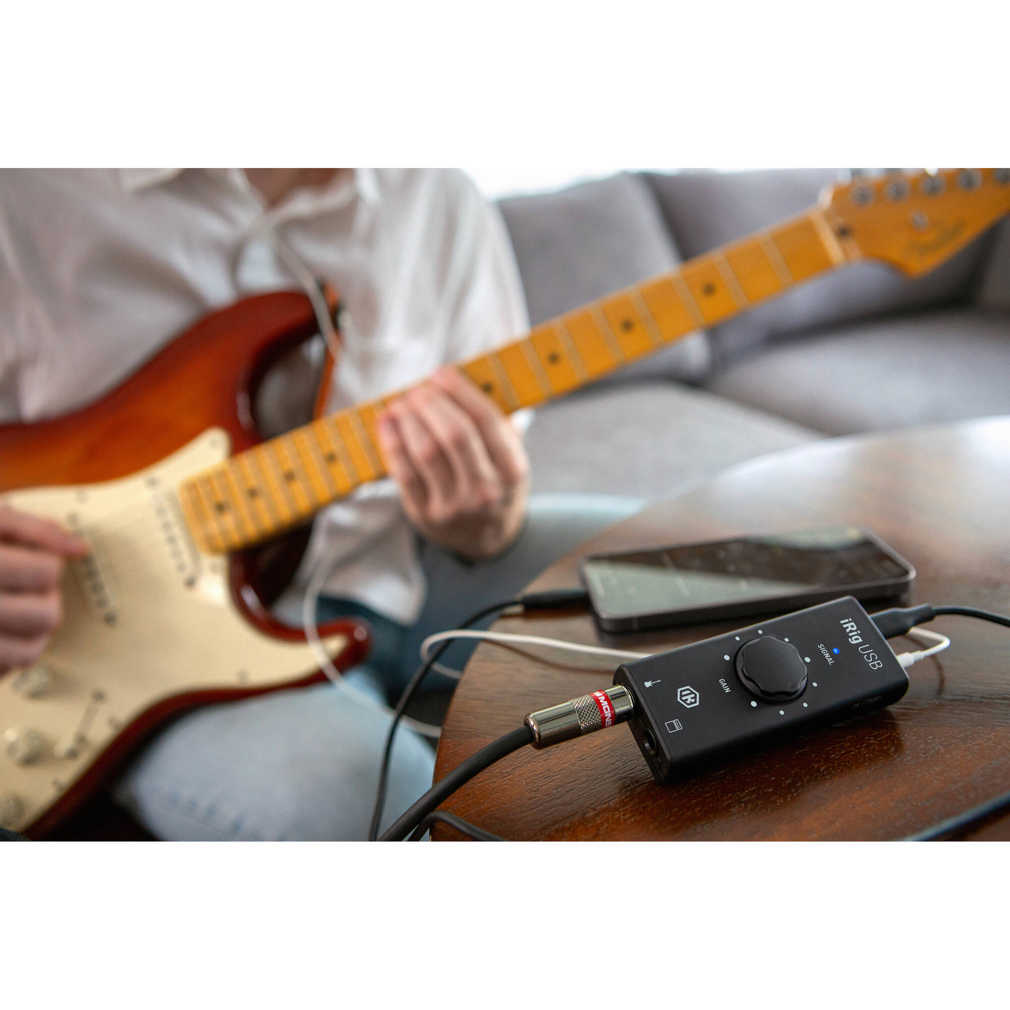 IK Multimedia iRig USB audio interface connected to a computer, showing input and output ports on a compact device.