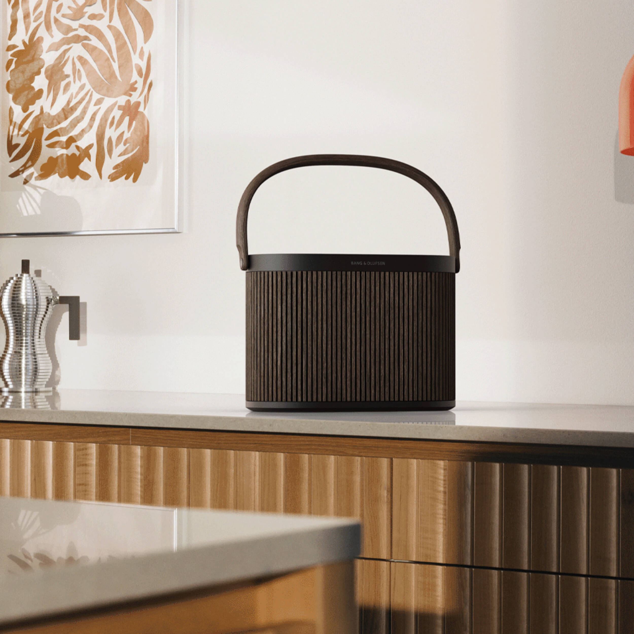 Bang & Olufsen Beosound A5 portable speaker in sleek black with fabric covering and control buttons on top, designed for high-quality sound.