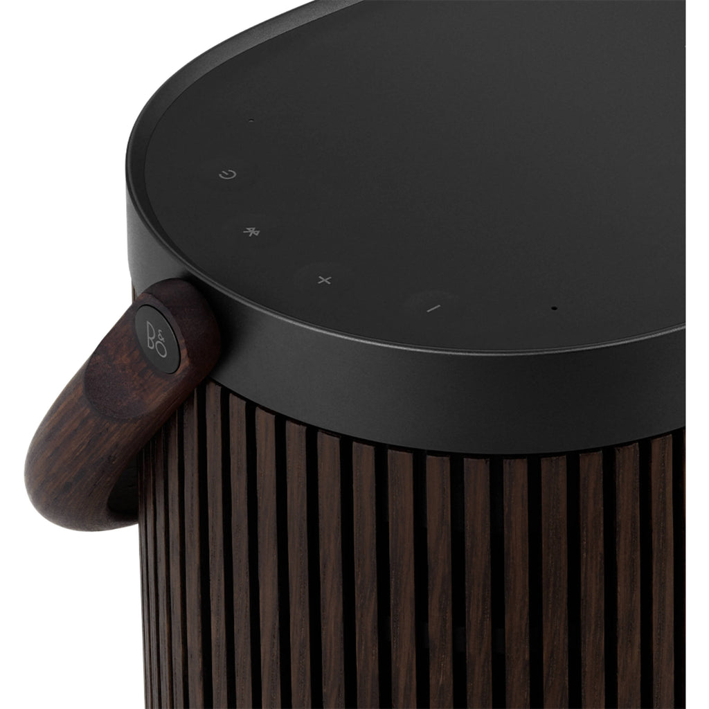 Bang & Olufsen Beosound A5 portable speaker with sleek design and fabric covering, shown on a wooden surface.