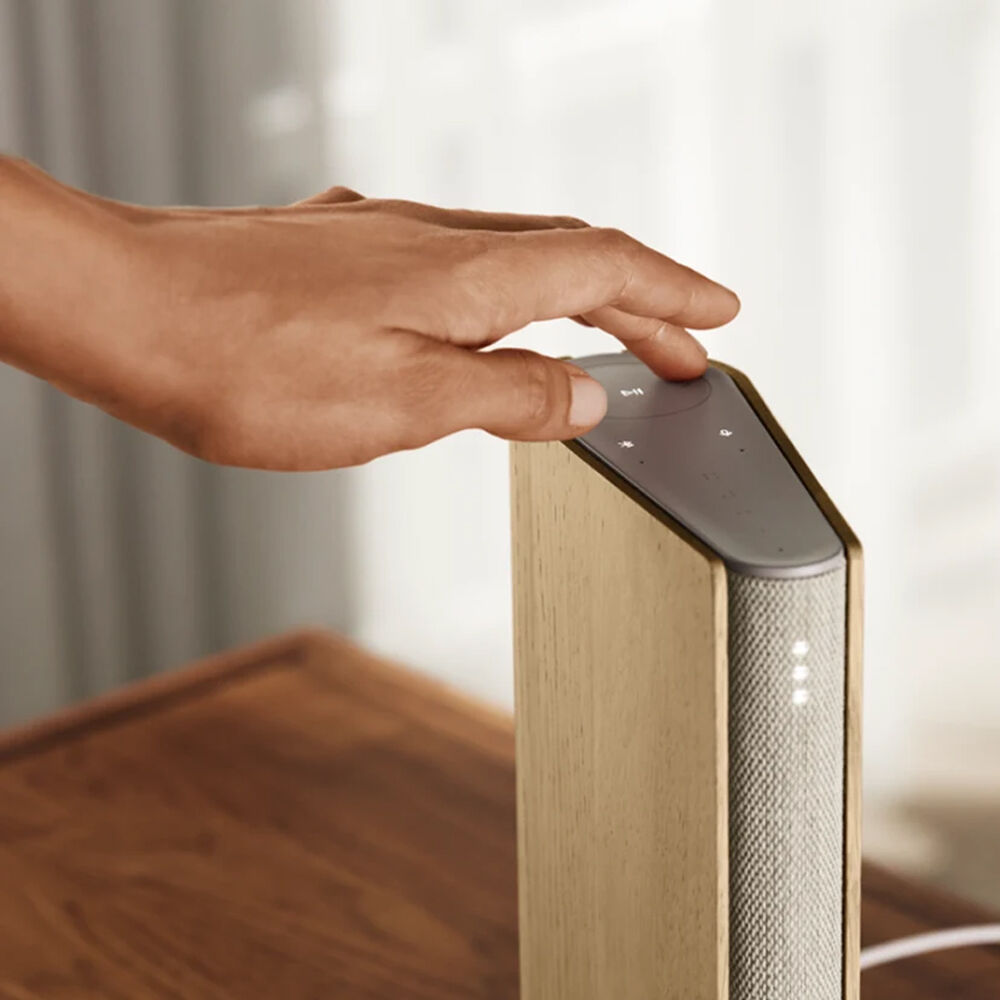Bang & Olufsen Beosound Emerge wireless speaker in elegant gold tone, showcasing its sleek design and compact form.