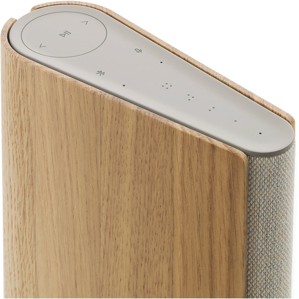 Bang & Olufsen Beosound Emerge wireless speaker in gold tone, sleek modern design with fabric grille and compact shape.