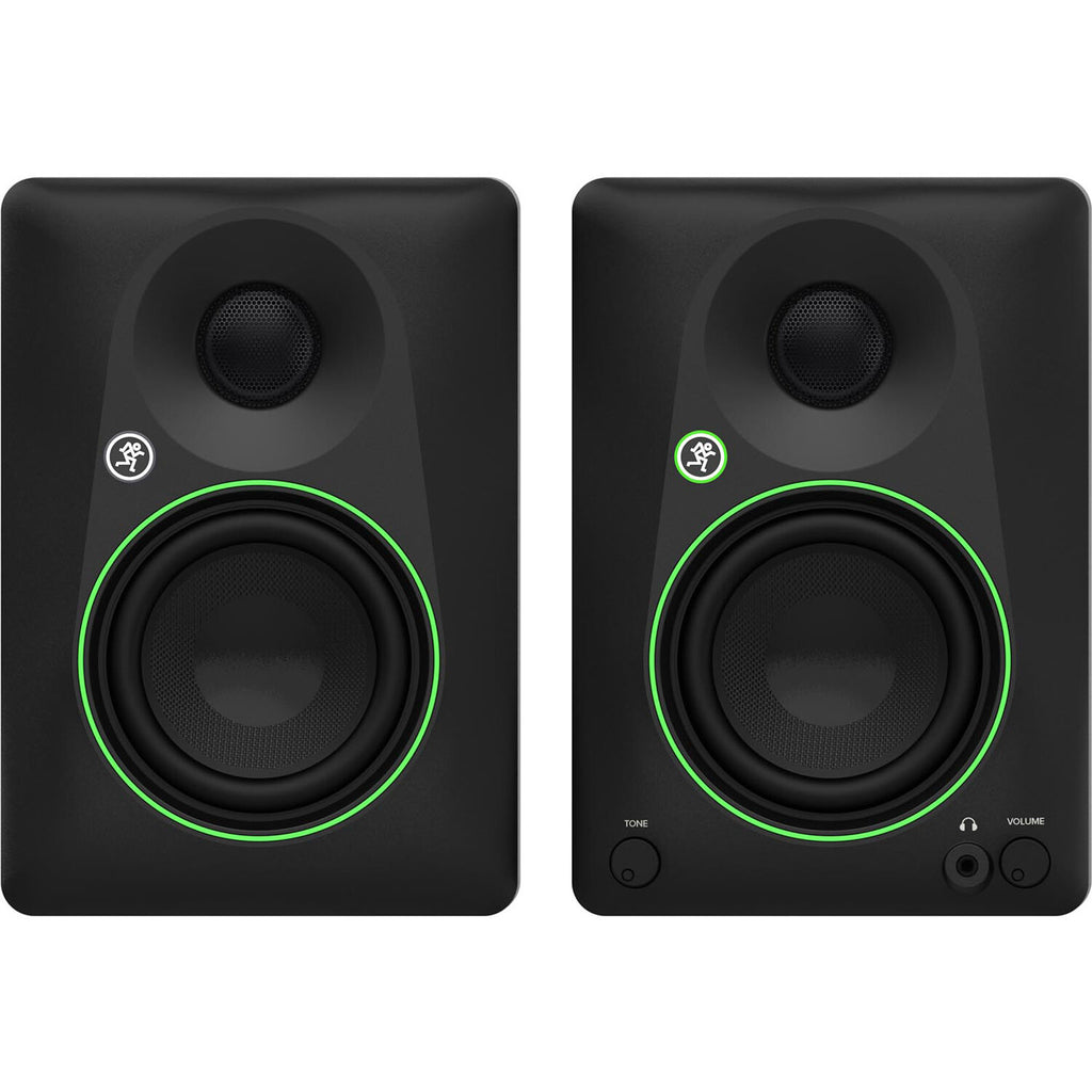 Mackie CR4.5 desktop speakers on a desk with audio equipment, showcasing the compact design and control knobs.