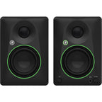Mackie CR4.5 desktop speakers on a desk with audio equipment, showcasing the compact design and control knobs.