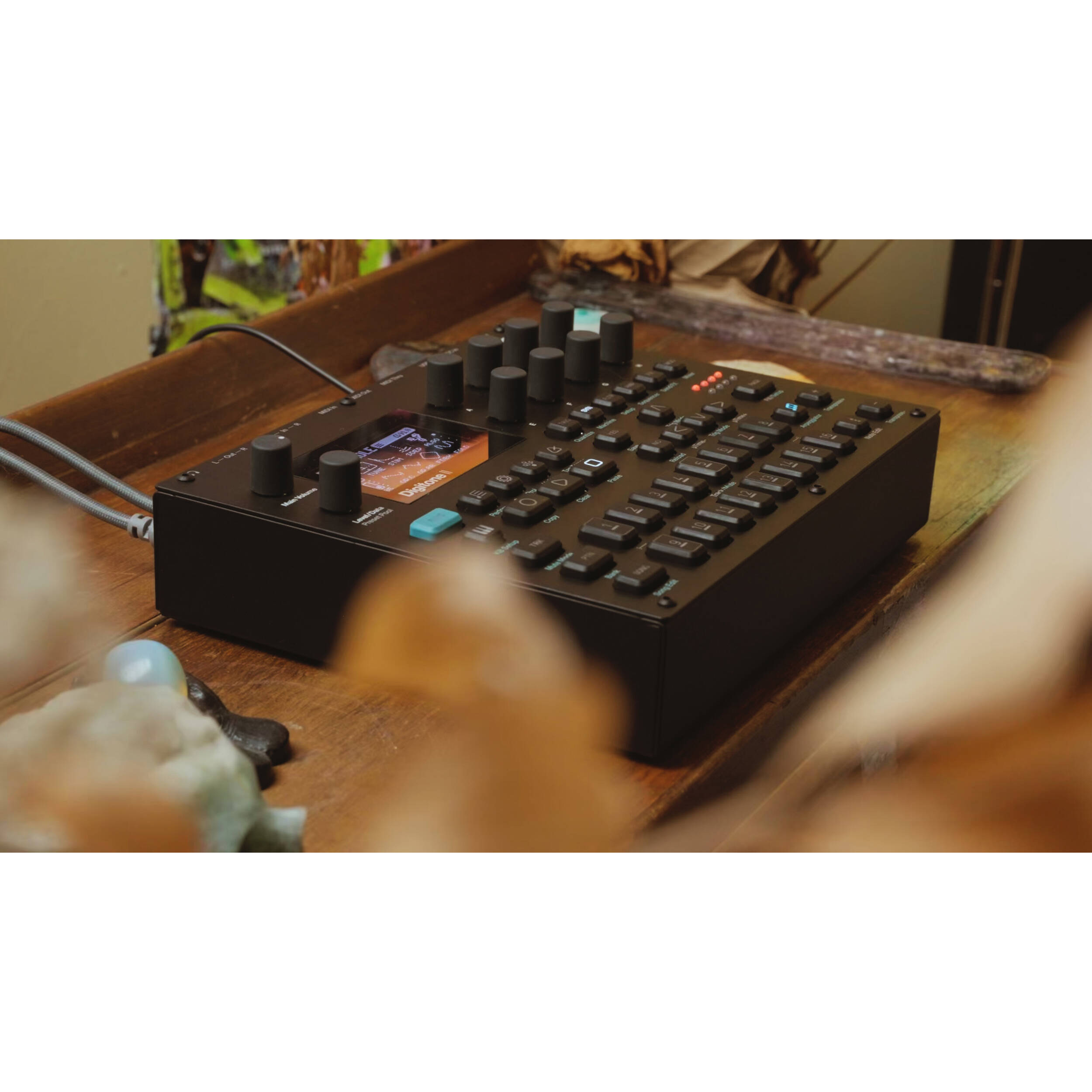 Elektron Digitone II synthesizer with a sleek black design and control knobs, displayed on a music production setup.