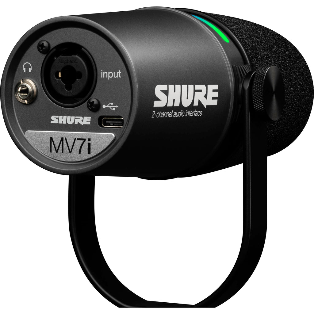 Shure MV7i USB microphone with black finish and built-in controls, positioned on a desk for podcasting or streaming setup.