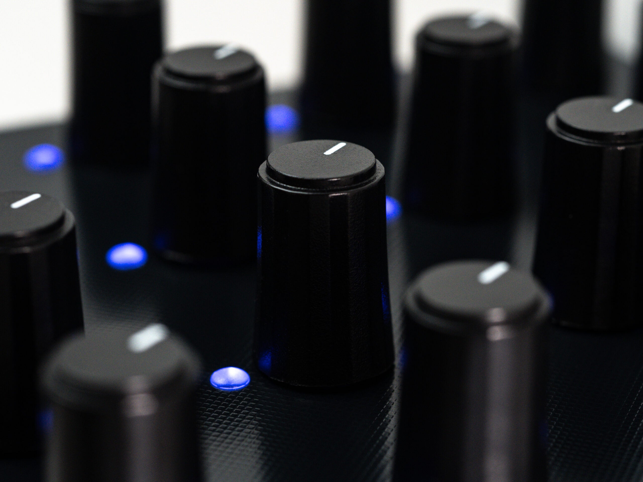 Close-up of Intech Studio PO16 Linear Series 3 MIDI controller with knobs and sliders for music production.