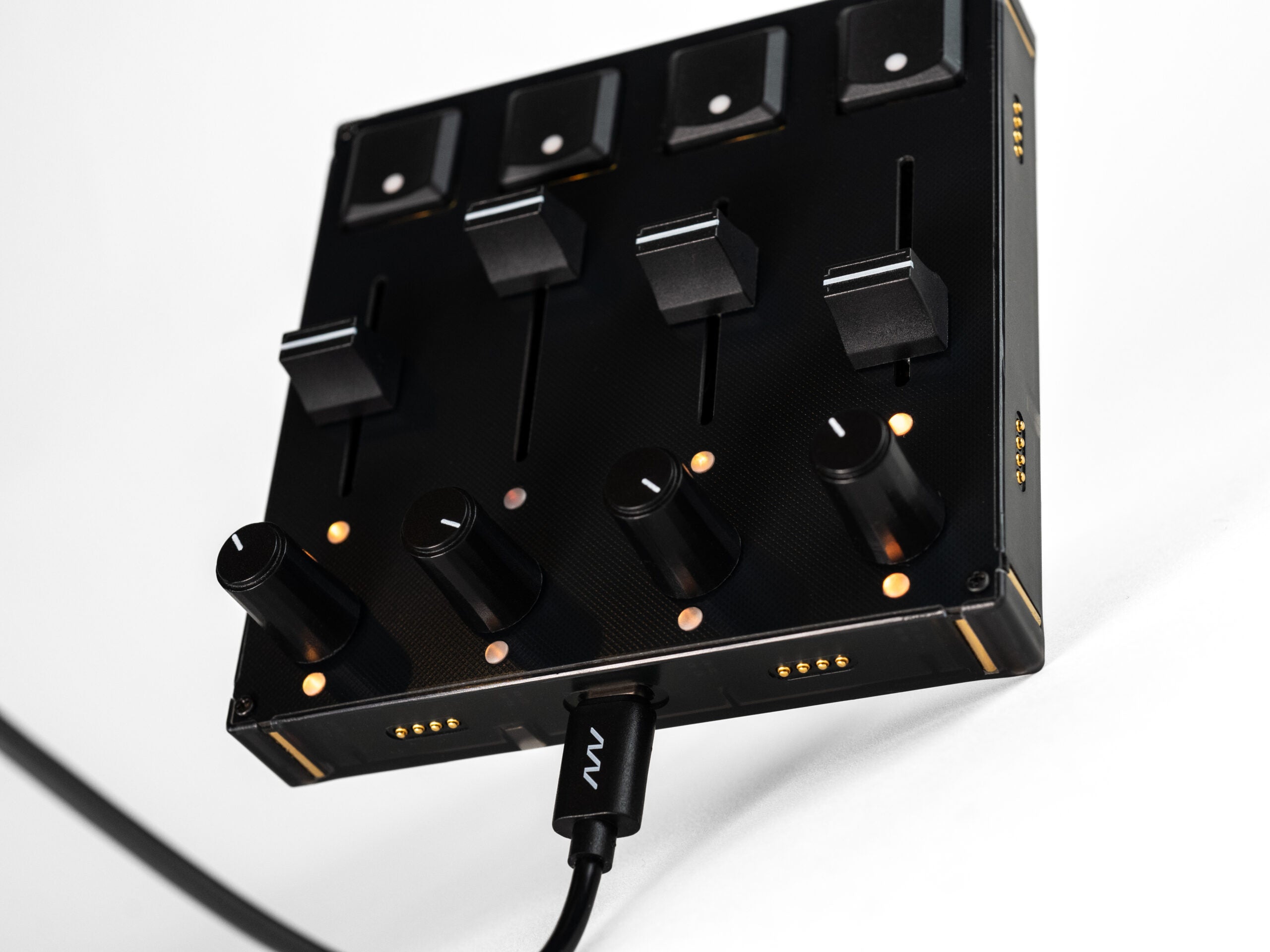 Close-up of Intech Studio PBF4 Series 3 MIDI controller with linear mechanical faders and control knobs.