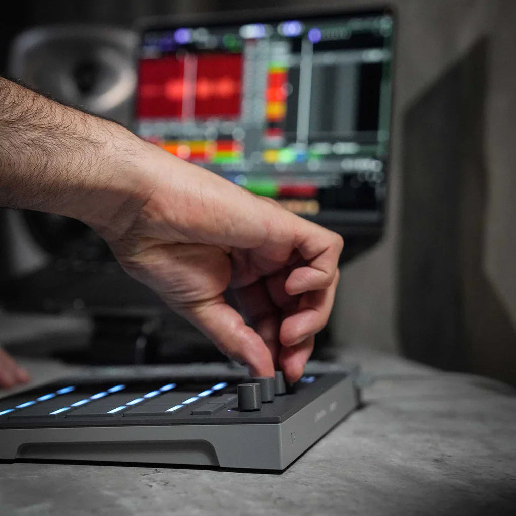 AlphaTheta SLAB MIDI controller with knobs, pads, and buttons on a sleek black surface for music production and performance.