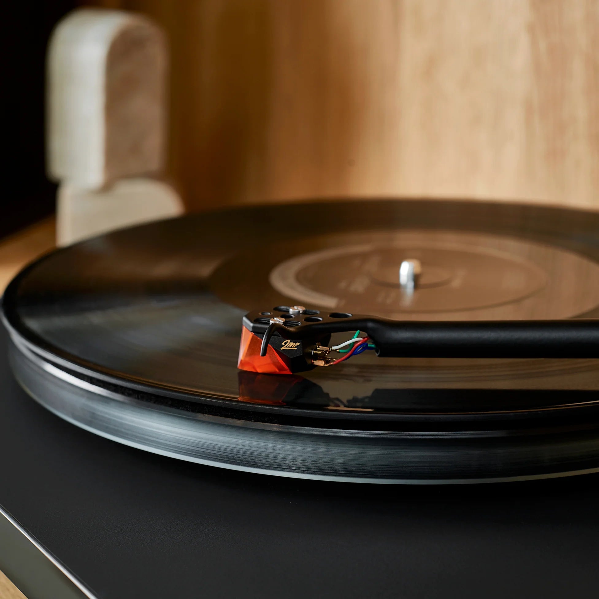Close-up of the Ortofon 2M Bronze turntable stylus showing the detailed needle and cartridge parts.