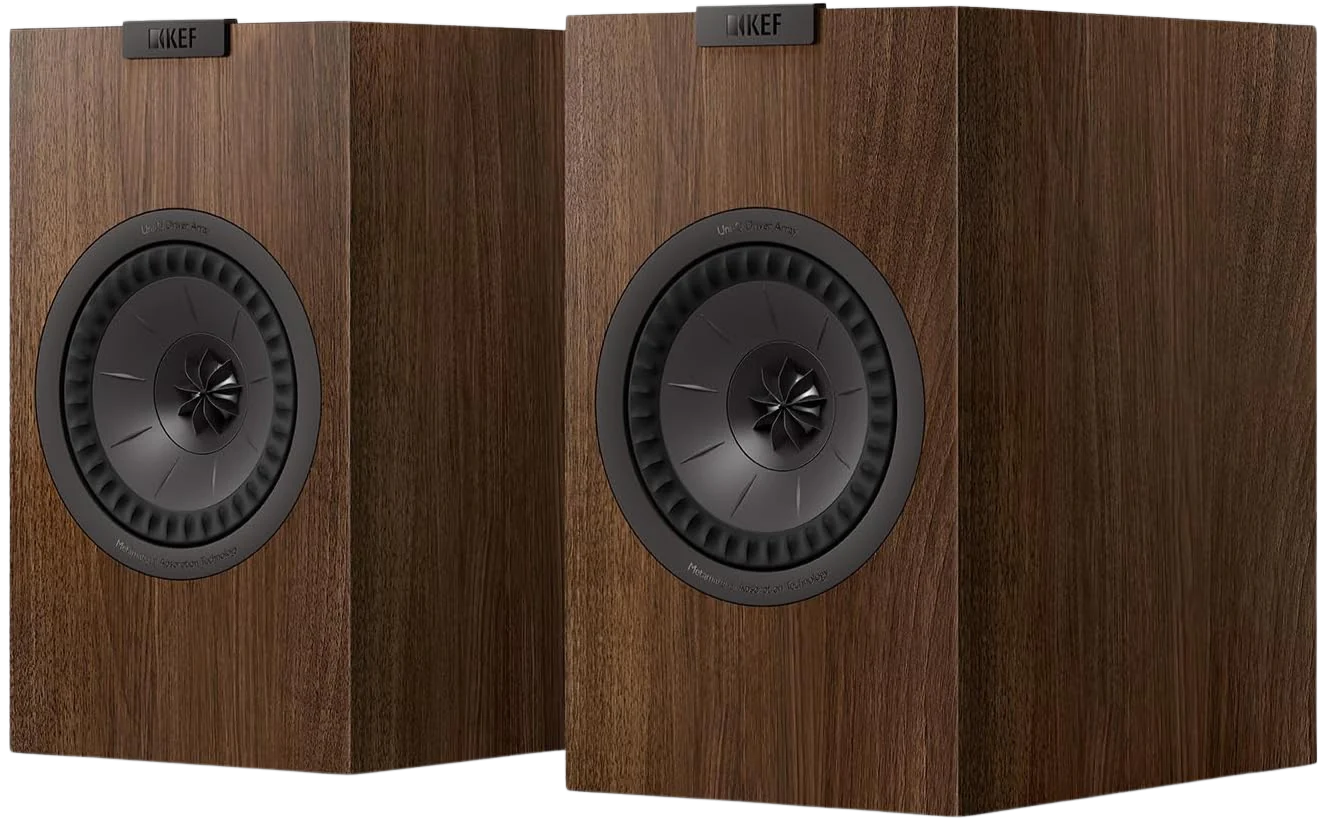 KEF Q3 Meta passive bookshelf speakers shown in a home audio setup with black cabinets and silver accents.