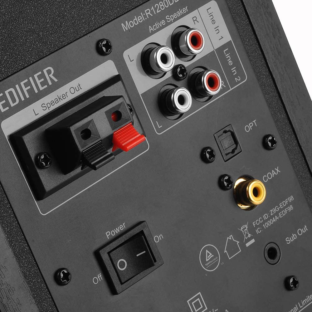 Edifier R1280DBS desktop speakers with wood finish, featuring control knobs and input ports visible on the front panel.