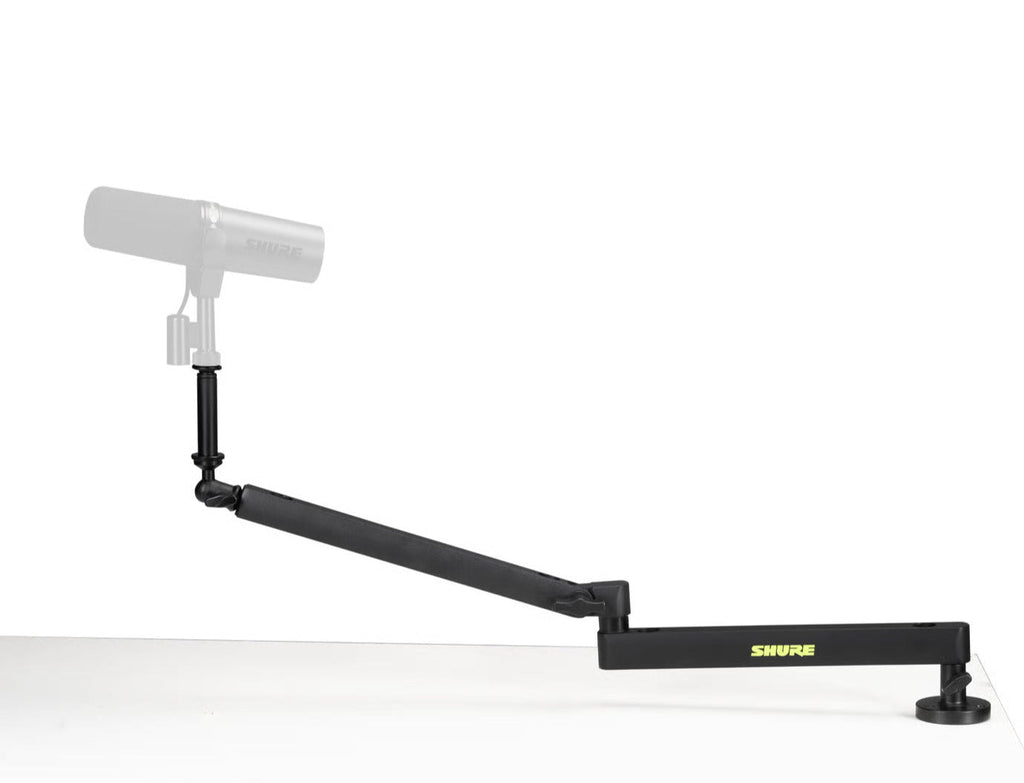 Shure SH-BROADCAST2 broadcast microphone arm mounted on a desk, adjustable arm for professional podcast or studio microphone setup.