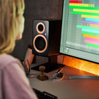 Argon Audio Forte A4 MK2 active bookshelf speakers on a black stand, showcasing their sleek design and compact size.