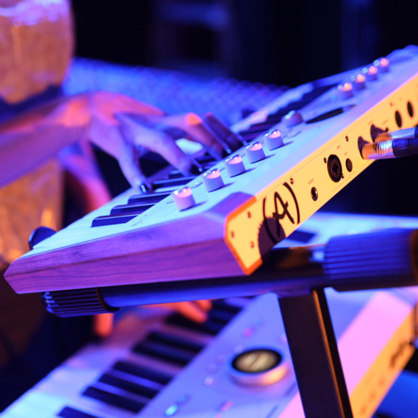 Arturia AstroLab 37 performance keyboard with black keys and compact design, featuring various control knobs and a sleek layout.