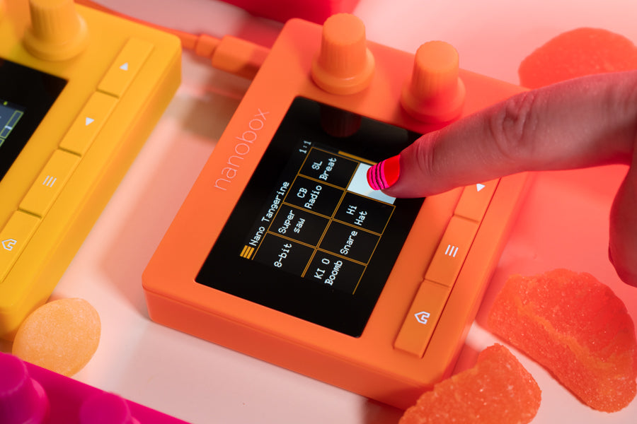 Desktop view of 1010music Nanobox Tangerine drum machine and sampler with colorful interface and control knobs.