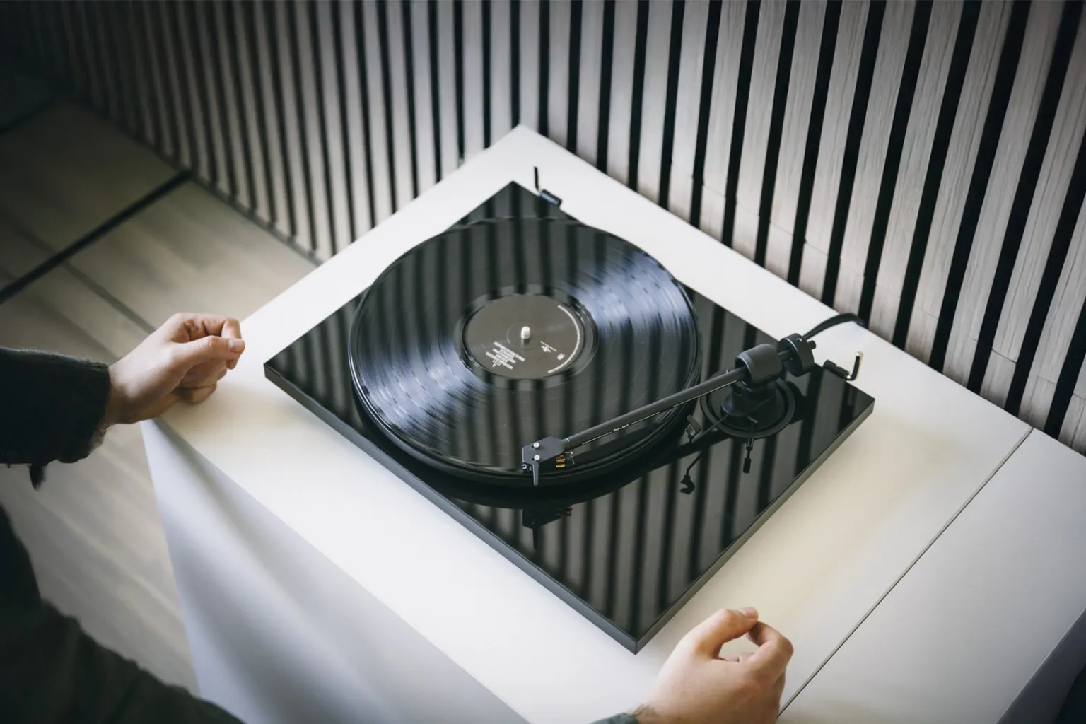 Pro-Ject E1.2 turntable with sleek design, featuring a wooden plinth and tonearm, ideal for high-quality vinyl playback.