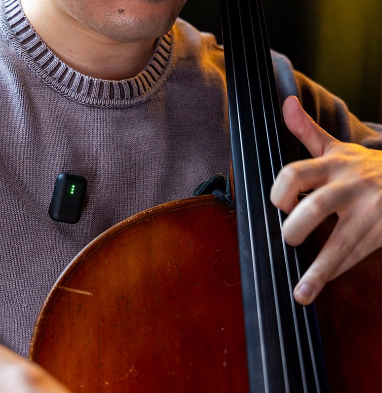 Instamic Pro Plus C Mono portable recorder with musician in background, compact black device for high-quality audio recording.