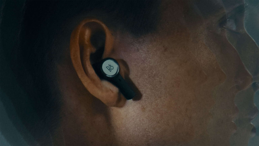 Wireless in-ear headphones by Bang & Olufsen Beoplay Eleven, shown in a lifestyle setting with call quality feature.