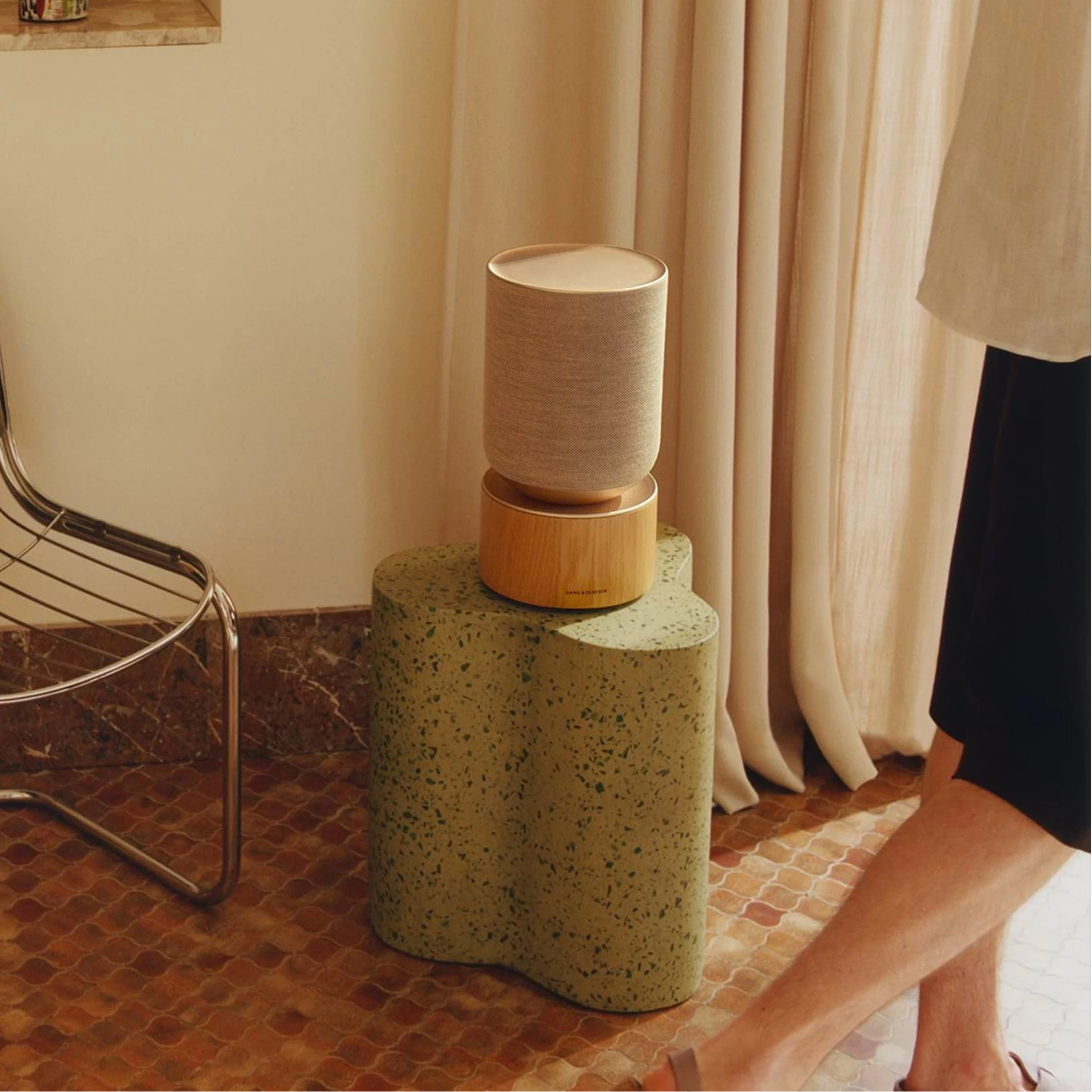 Bang & Olufsen Beosound Balance wireless speaker in a modern living room setting, showcasing its sleek design and premium build.