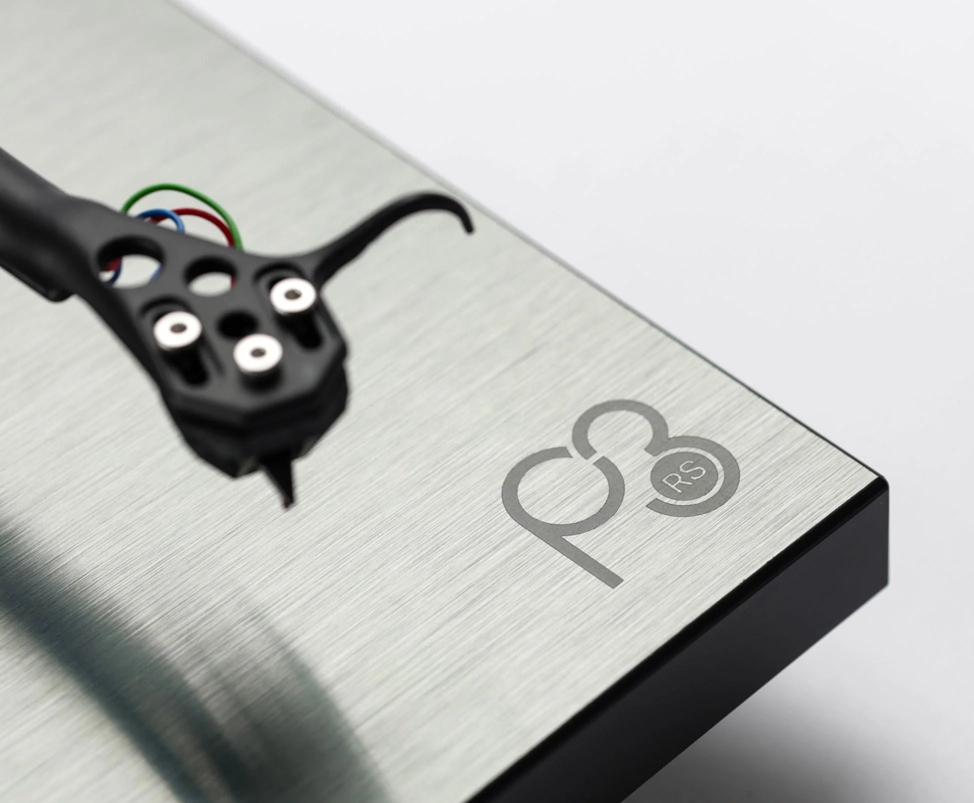 Close-up of Rega Planar 3 RS turntable with aluminum plinth and Nd5 cartridge, showing the tonearm and platter details.