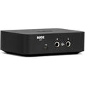 Rode AI-1 audio interface shown from a three-quarter left back angle, featuring input and output ports on a sleek black device.