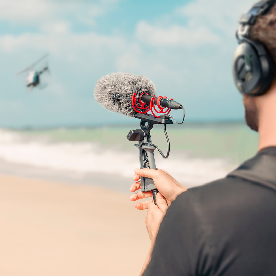 Rode NTG5 camera microphone mounted outdoors on a boom pole, ready for professional audio recording in a scenic beach setting.