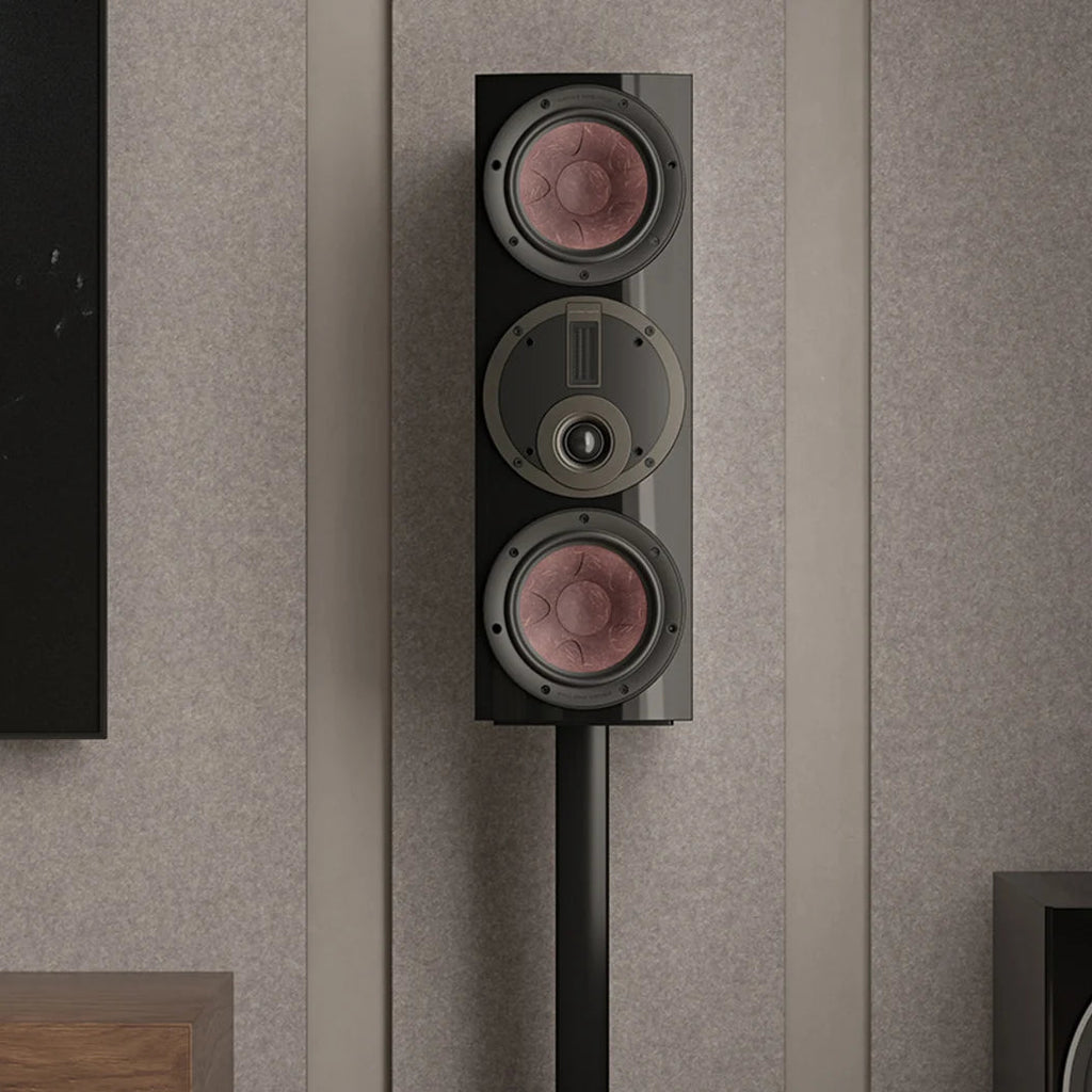 DALI Rubikore Cinema center speaker placed on a living room shelf, showcasing sleek black design and compact size.