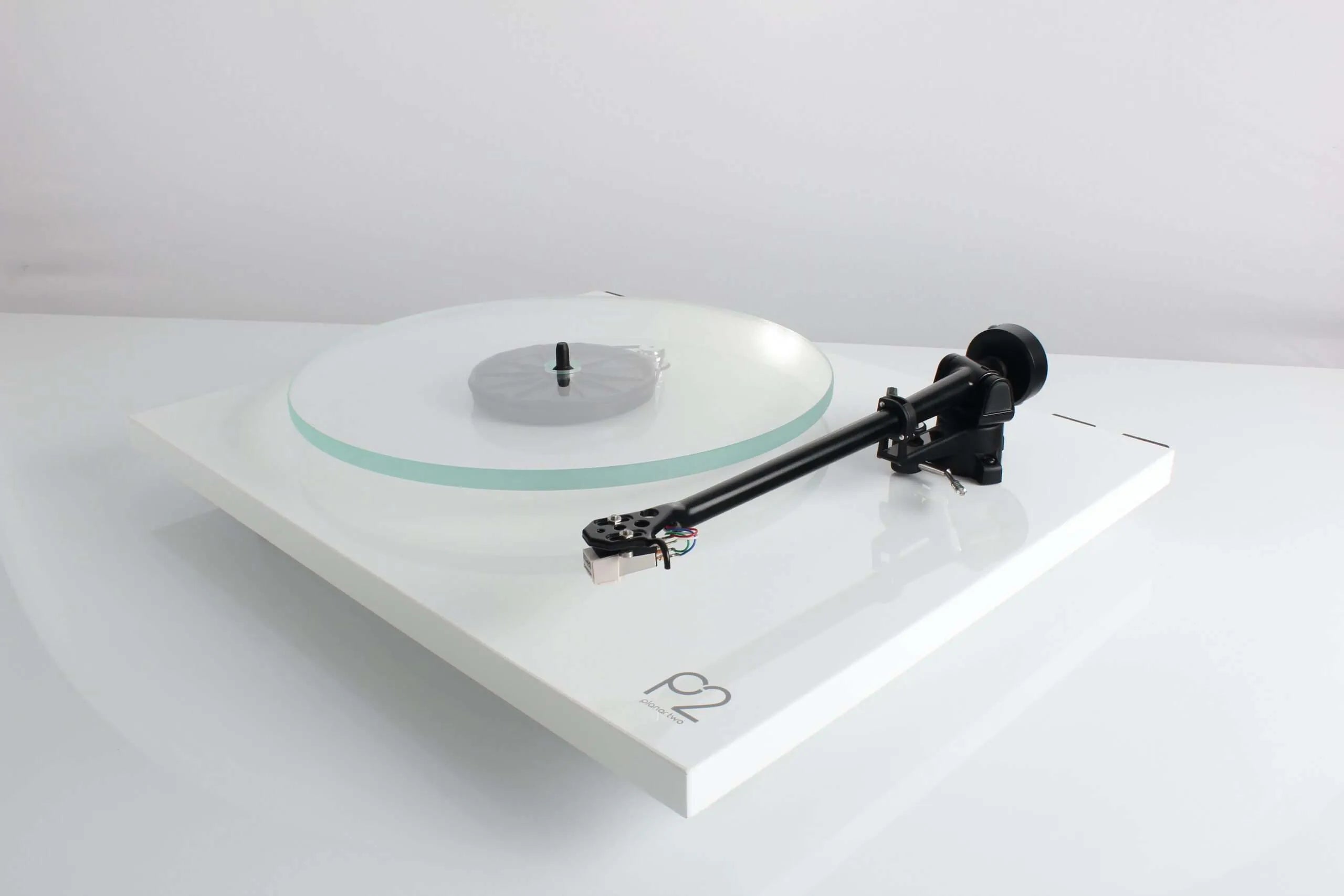 Rega Planar 2 turntable with Nd3 cartridge, showcasing its sleek design and tonearm on a wooden surface.