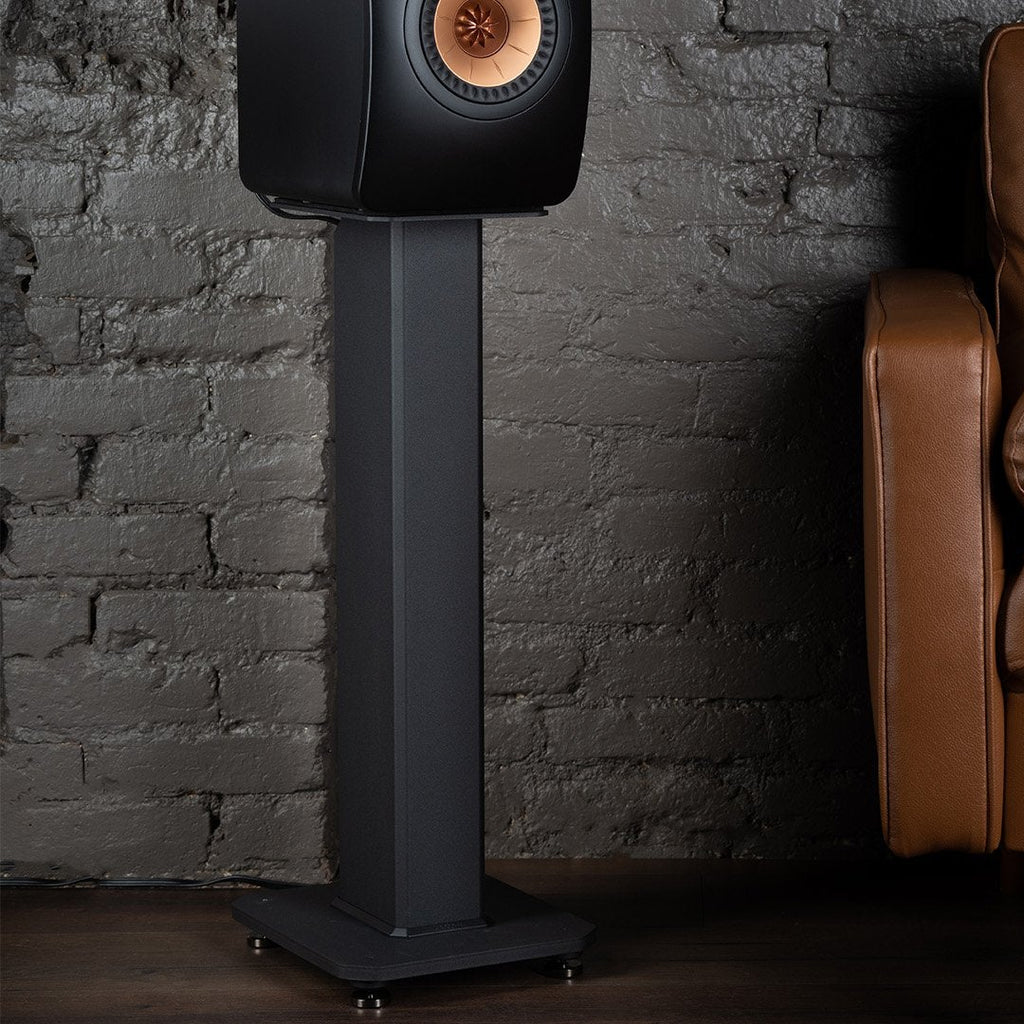 Kanto Audio SX 22-inch speaker stand supporting a speaker in a living room setting with a couch.