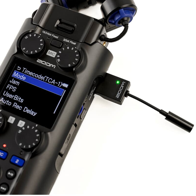Zoom TCA-1 recorder accessory attached to a portable audio recorder, showing connection ports and compact design.