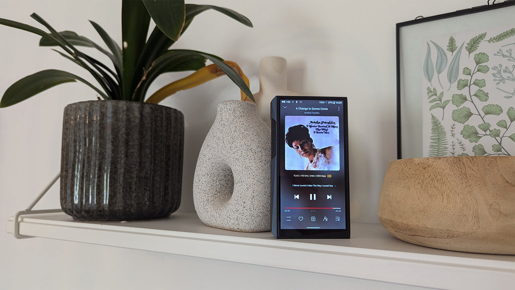 FiiO M23 portable music player with a sleek display, control buttons, and headphone jack, showcasing its modern compact design.