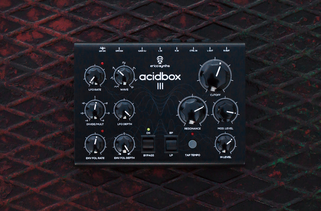 Erica Synths Acidbox III effect pedal with multiple control knobs and input/output jacks, used for acid sound effects.