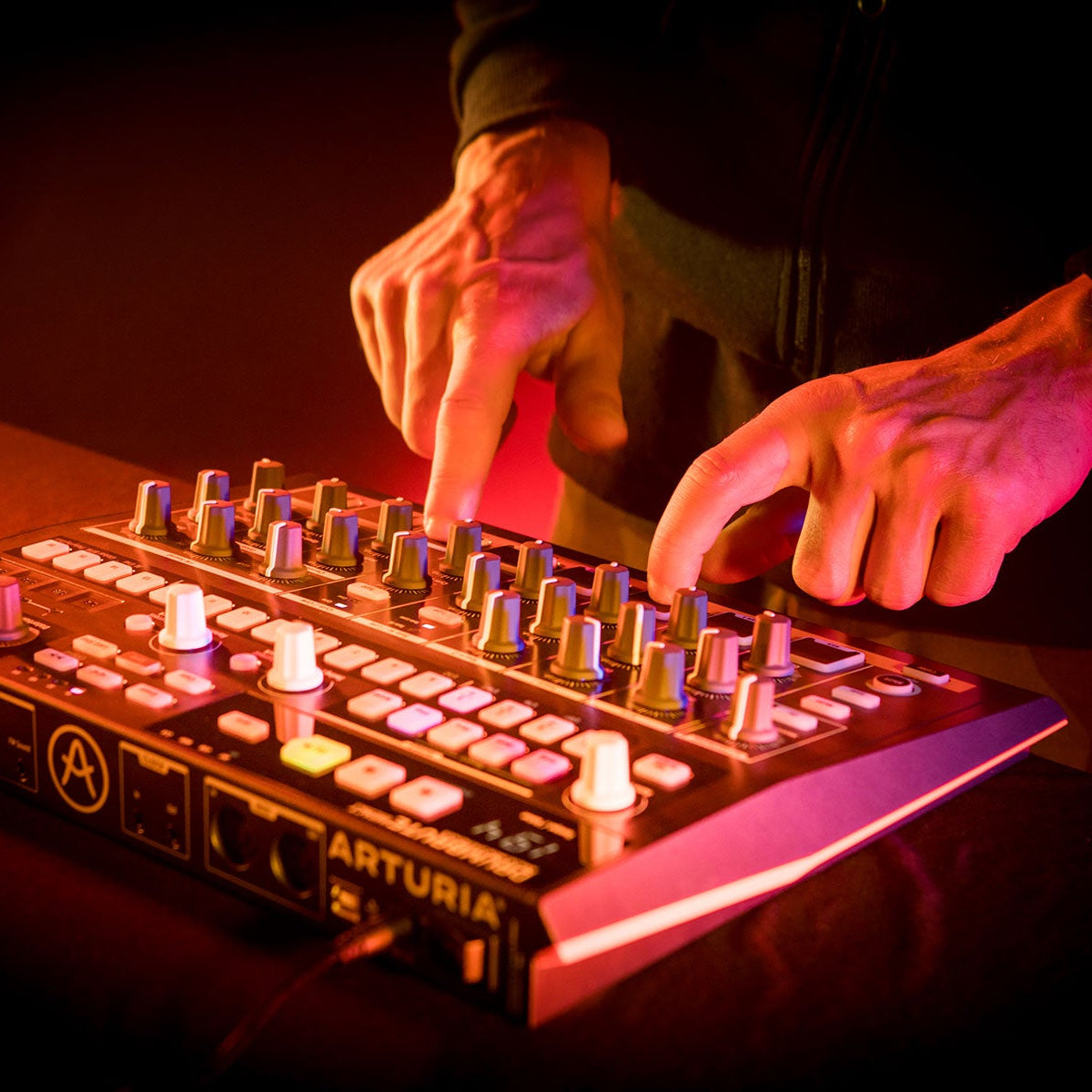 Arturia DrumBrute Impact drum machine with colorful pads and control knobs for electronic music production.