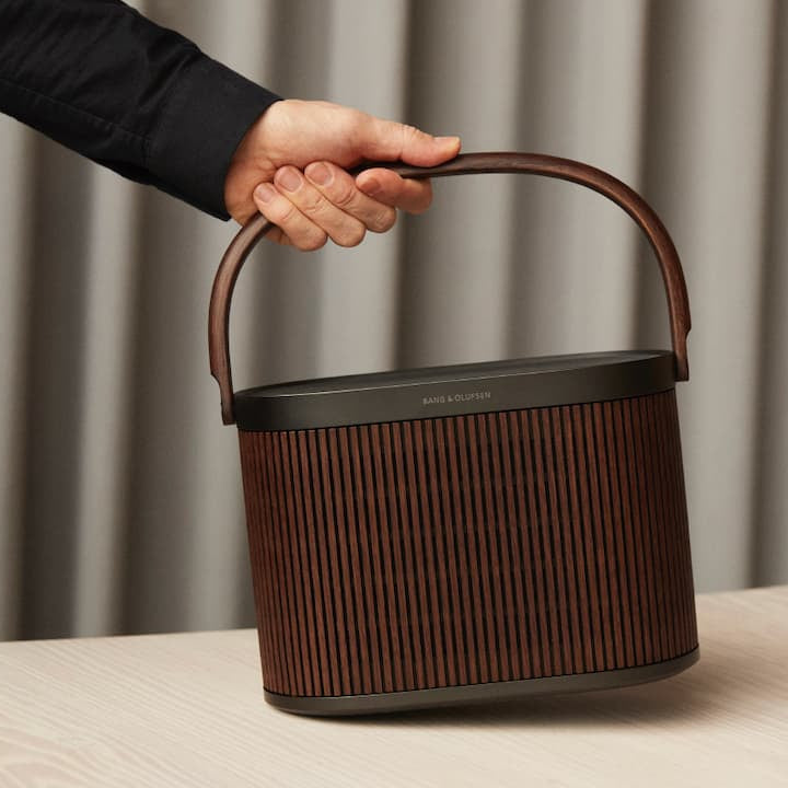 Bang & Olufsen Beosound A5 portable speaker held in hand, showcasing its sleek design and compact size.