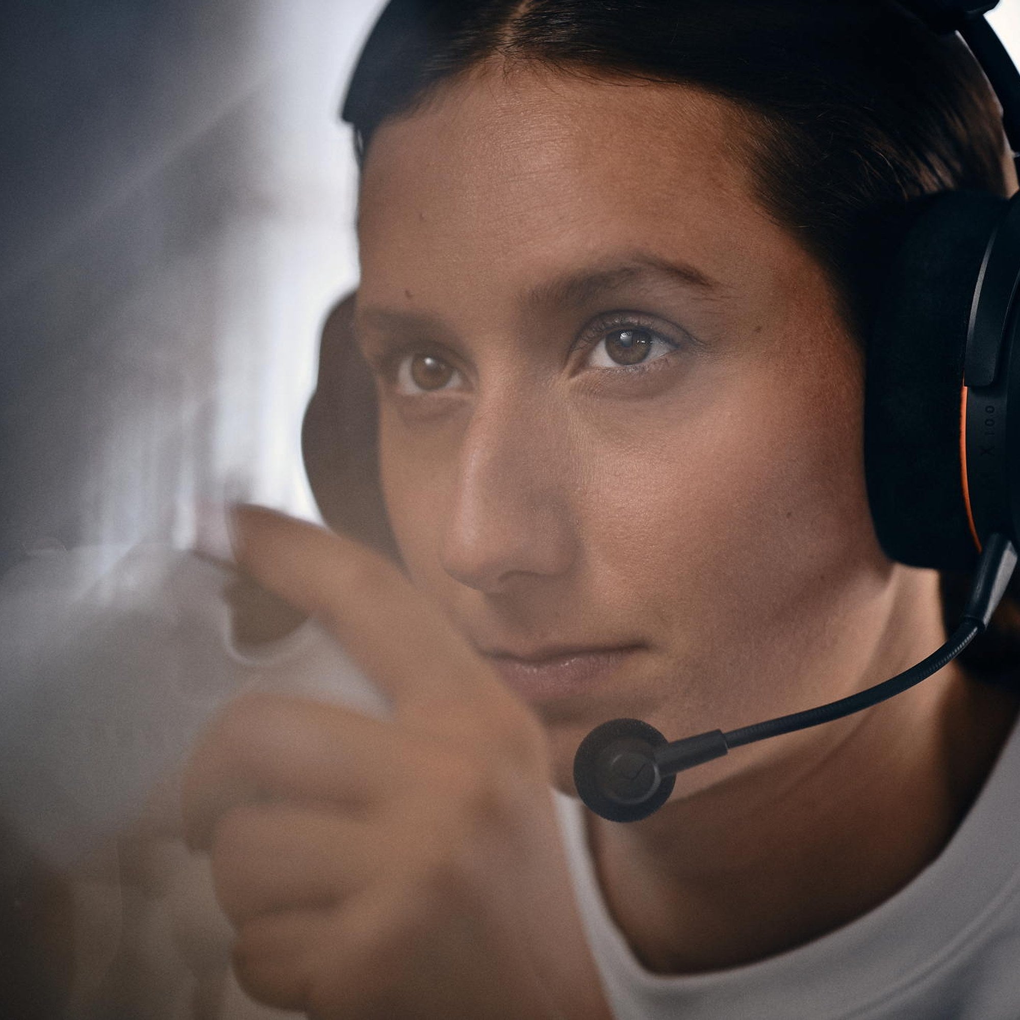 Woman wearing the Beyerdynamic MMX 100 Wireless headset while relaxing on a sofa