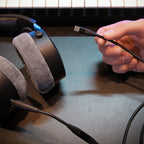 Beyerdynamic Pro X USB-C Cable held next to DT 900 Pro X headphones on a studio desk