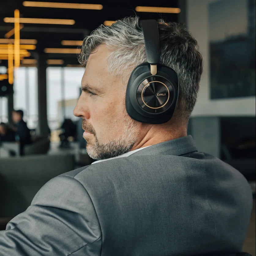 DALI Dali iO-12 wireless headphones resting on a surface with a sleek, modern design and soft ear cushions.