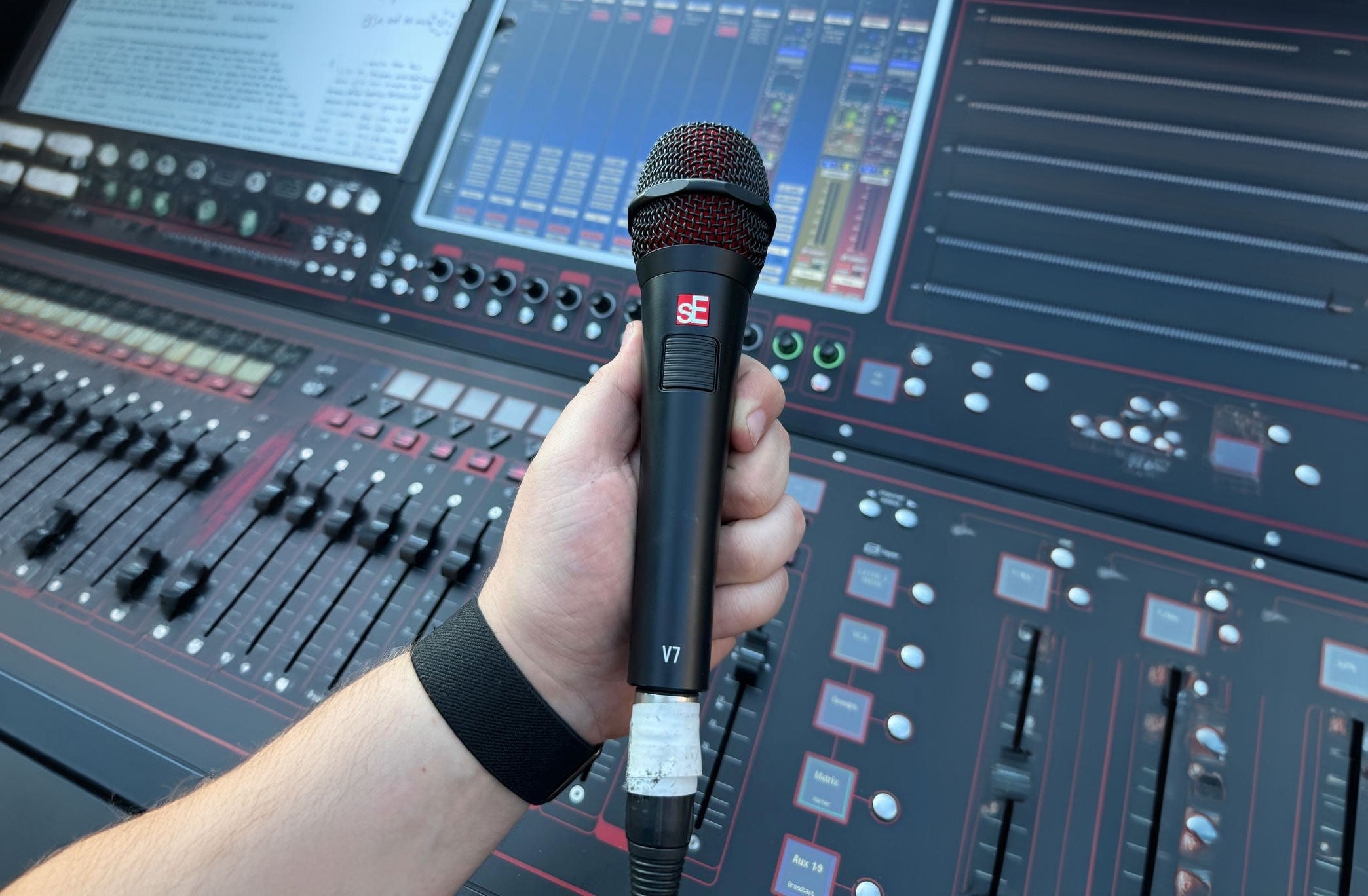 SE Electronics V7 PTT dynamic microphone, shown in a wide shot, highlighting its professional design and build quality.